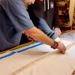 Two craftsmen working on fabric for window treatment