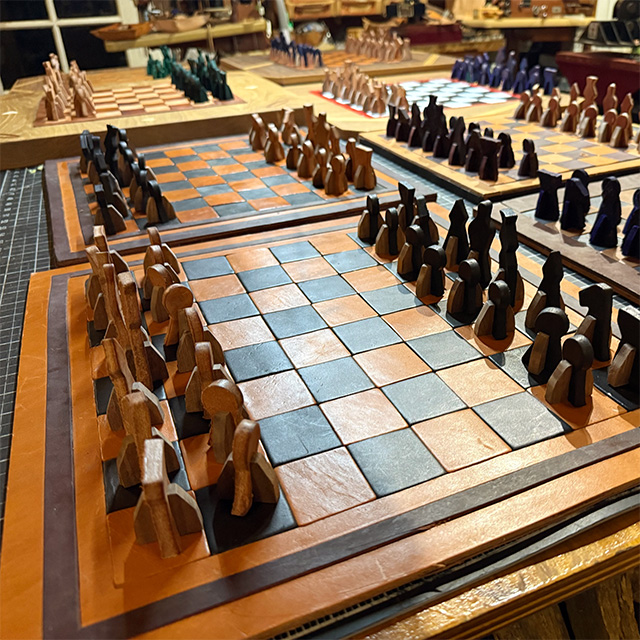 Numerous leather chess sets on top of a table