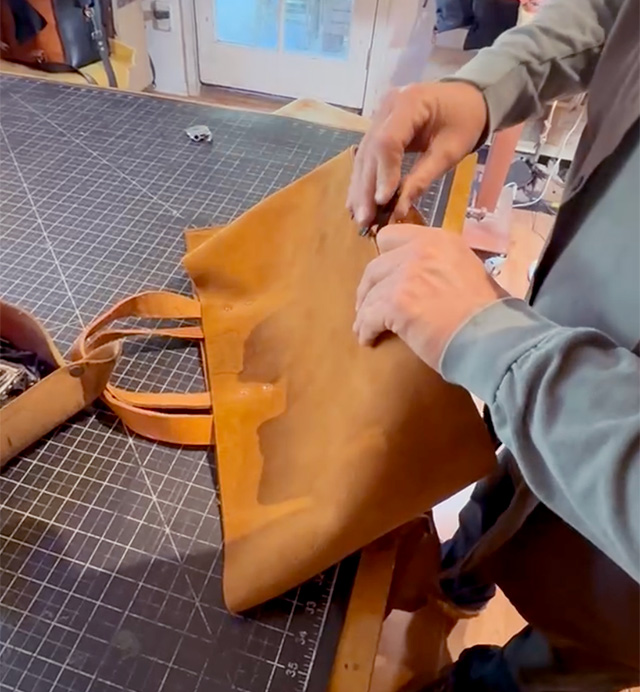 Person working with the leathr tool bag on a crafting table