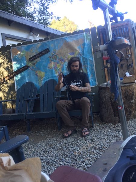 Jay is hand lacing a wheel set under the oak trees in Topanga