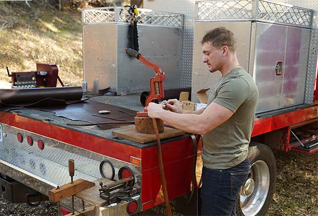 Punching rivets in the belt in the back of the fire truck