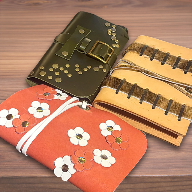 3 various styles of journal covers on top of a wooden table