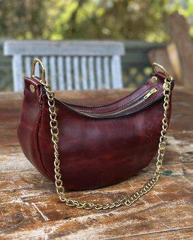 Crescent bag with a yellow chain strap provides an elegant look