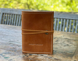 Leather journal cover with UnPredict Your Journey stamped on the cover