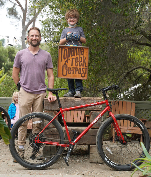 The kid is as excited as the dad to pick up the Surly Bridge Club