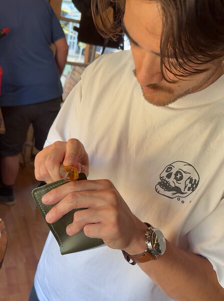 Customer applying wax to the edge of the wallet before burnishing