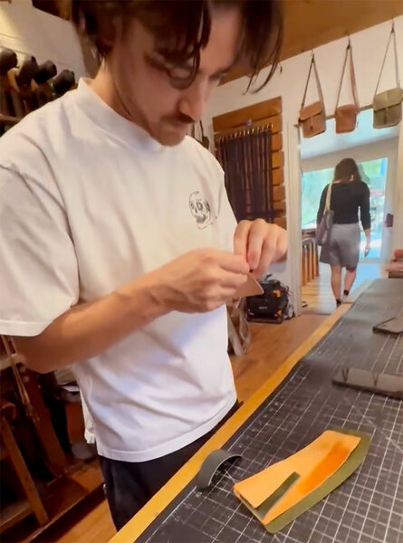 Customer hand sewing the wallet in our wallet workshop
